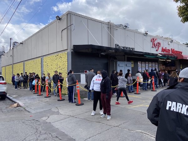 Many people are waiting in front of an Asian supermarket.